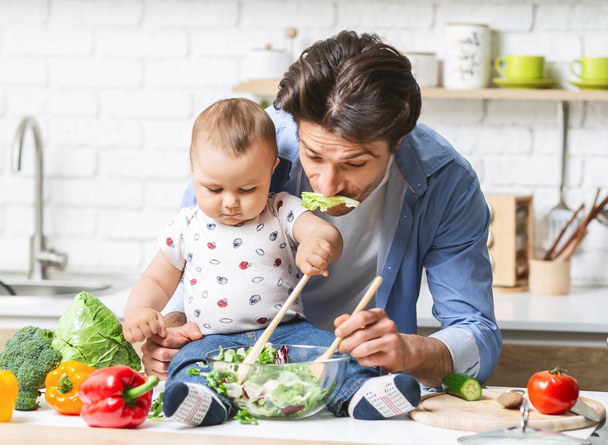 Divertente papà preparare il pranzo con il bambino figlio in cucina
 - Foto, immagini