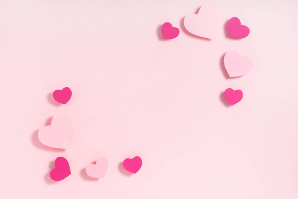 Valentins Tagesrahmenkomposition. lila rosa Herzen auf pastellrosa Hintergrund. Draufsicht, flache Lage, Kopierraum - Foto, Bild