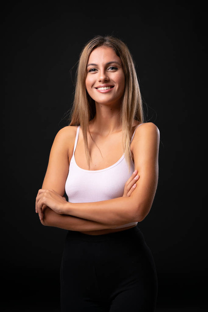 Young blonde woman over isolated black background - Foto, Imagem
