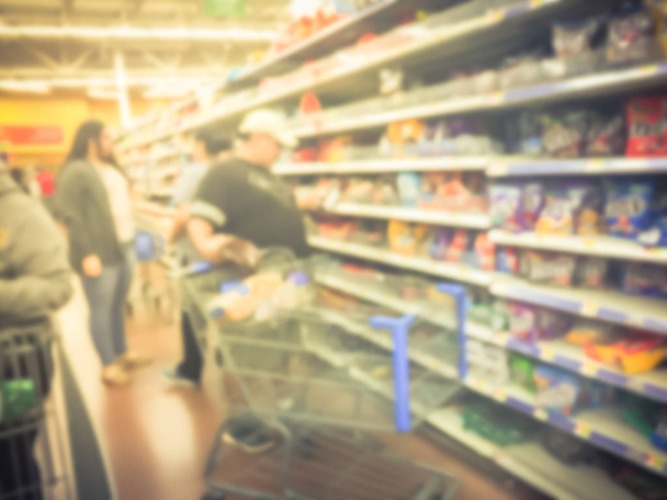 Hämärä tausta asiakkaita ostoskorin varastossa karkkia ruokakaupoissa Amerikassa
 - Valokuva, kuva