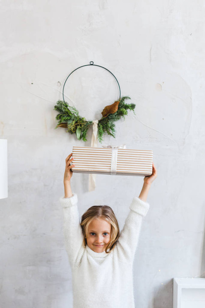 Girl holding gift, interior decoration for new year and Christmas - Fotoğraf, Görsel