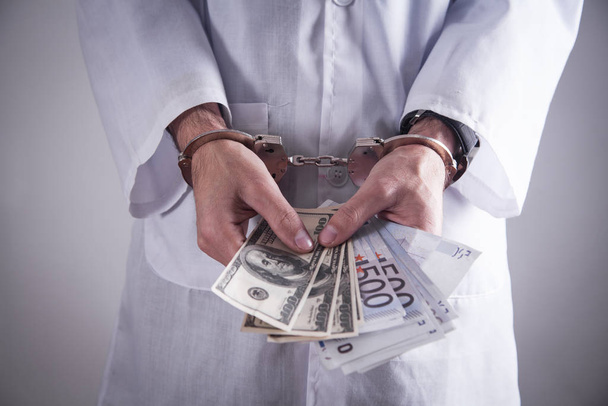 Doctor with handcuffs and money. Medical crime - Foto, Imagem