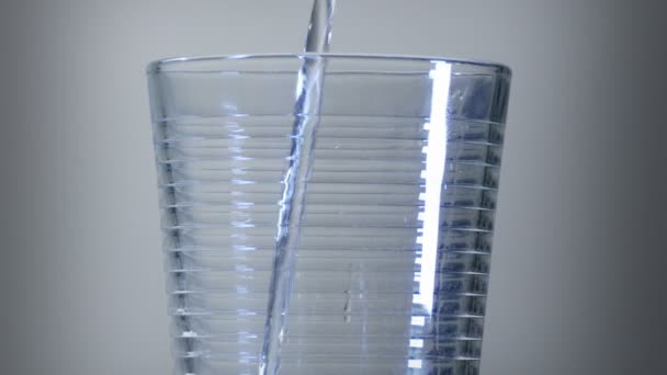 Exhibición de agua cayendo en un vaso en una silueta de ligto azul
 - Imágenes, Vídeo