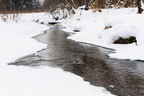 Snowy winter landscape of river and forest - Foto, afbeelding