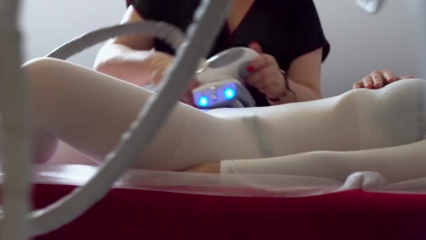El esteticista hace masajes anticelulíticos a un paciente. Chica en sesión de masaje de GLP en salón de belleza
 - Metraje, vídeo