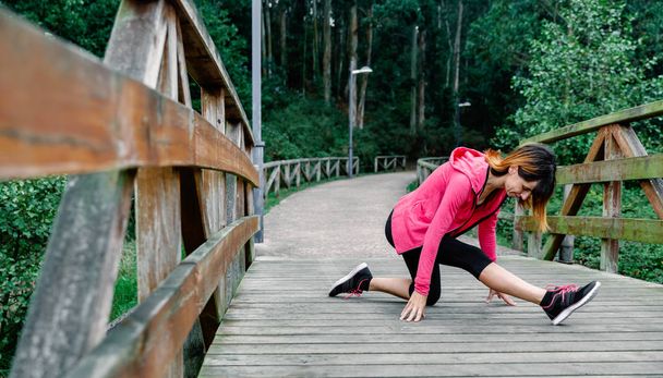 Sportowiec kobieta robi rozciągnięcie nogi - Zdjęcie, obraz