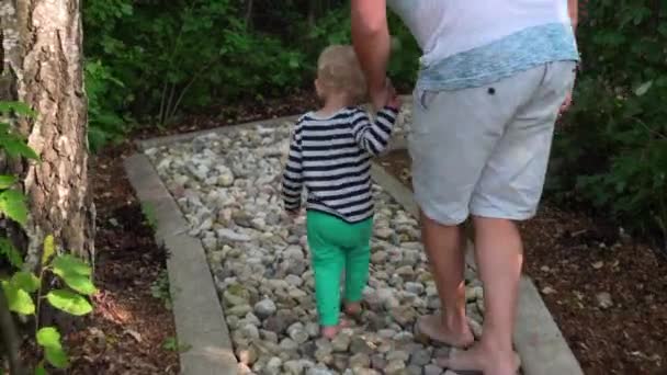 Ο μπαμπάς με το μικρό γιο περπατώντας μέσα από υγιή πόδι ξυπόλυτος μονοπάτι μασάζ - Πλάνα, βίντεο