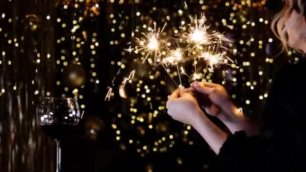Uma mulher sorri e segura nas mãos um sparkler de 2020 forma. Feliz Ano Novo 2020
. - Filmagem, Vídeo