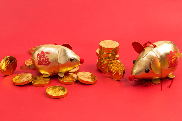 Monedas de oro, lingote de oro y mascota para el año de la rata
 - Foto, imagen