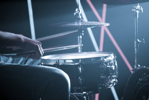 muž hraje na bicí. Na pozadí barevných světel. - Fotografie, Obrázek