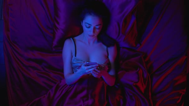 Workaholic girl scrolling gadget in bed at night lack of sleep, insomnia problem - Πλάνα, βίντεο