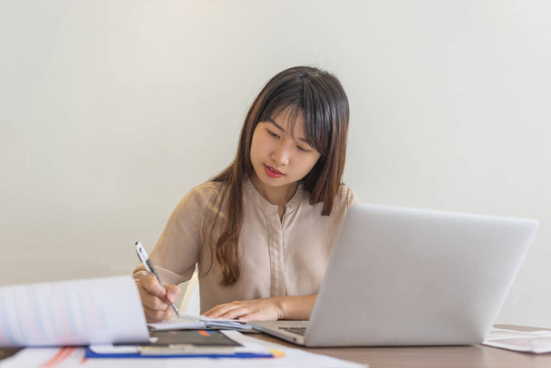 Close-up of businesswoman writing notes in office - Foto, Imagen