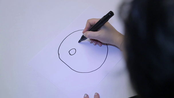 Uma mulher em um psicólogo passa por um teste psicológico, desenha um humor com um emoticon em marcador preto
 - Filmagem, Vídeo