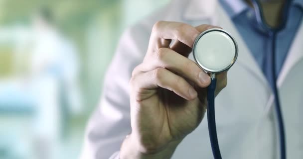 egészségügy és kutatás - orvos áll a klinika folyosóján sztetoszkóppal a kezében közelkép - Felvétel, videó