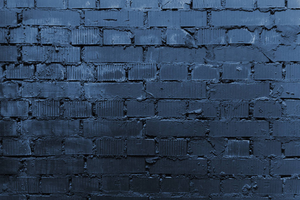 Pęknięta i teksturowana niebieska ściana, ceglane tło ściany. Kolor koncepcji roku 2020. Zamknij drzwi. Modny klasyczny niebieski kolor sezonu wiosna-lato 2020 z Nowego Jorku tydzień mody - Zdjęcie, obraz