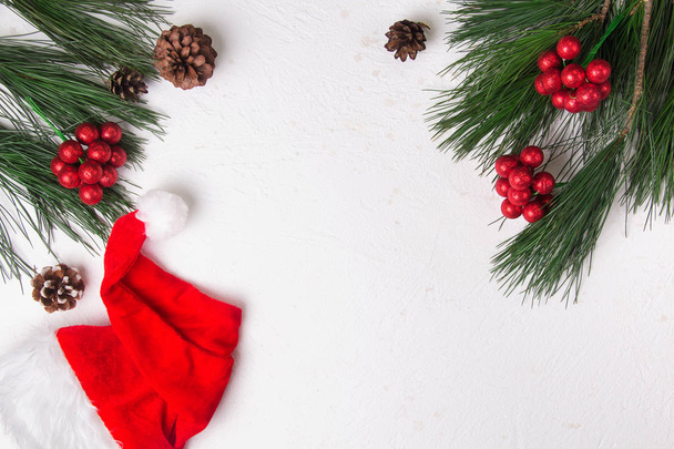 Рождественский фон с елкой и шляпой Санты на белом фоне. Плоский лежал. Mockup
. - Фото, изображение