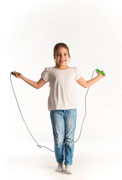 Cheerful girl in casual clothes jumping on rope - Foto, immagini