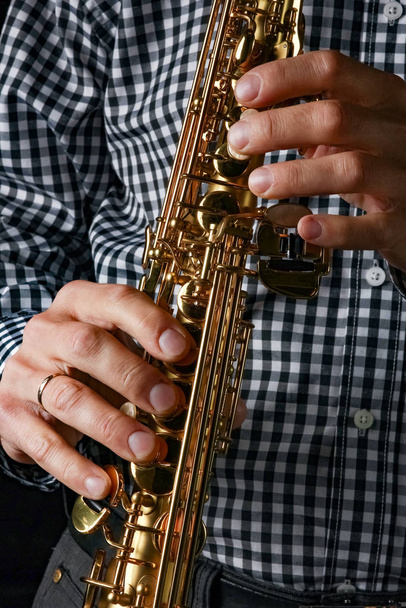 soprano saxophone in hands on a black background - Fotografie, Obrázek
