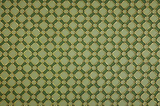 Текстура декоративного золотого орнаменту на зеленій стіні
. - Фото, зображення