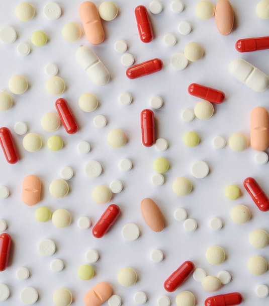 Farmacologia medicamentos variados pílulas, comprimidos e cápsulas textura padrão de fundo. Tablet cores diferentes no fundo branco. Vista superior com espaço de cópia
 - Foto, Imagem