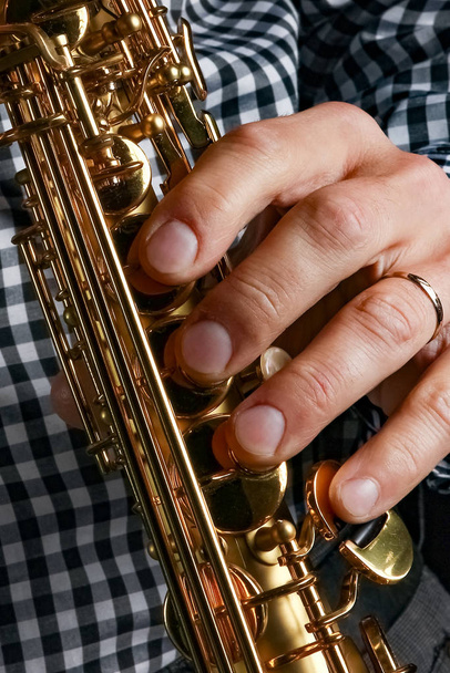 soprán saxofon v rukou na černém pozadí - Fotografie, Obrázek