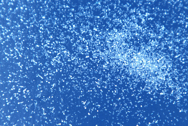 Αφηρημένο χιόνι γκλίτερ φόντο στην κλασική μπλε επιφάνεια. - Φωτογραφία, εικόνα