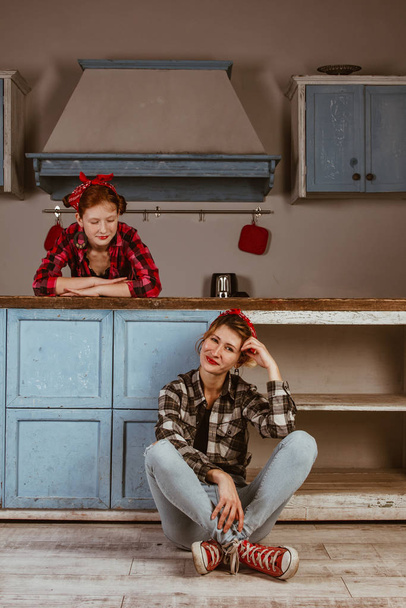 Family, friendship and people concept - happy mother with little daughter. With red lips in a bandana have fun in the home kitchen. Pin-up style photo. - Fotó, kép