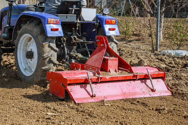 Farmer felszántja a földet. Kis traktor szántással a mezőn. Termesztés. - Fotó, kép