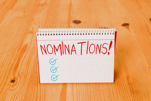 Handwriting text writing Nominations. Concept meaning action of nominating or state being nominated for prize Empty reminder wooden floor background spiral notebook groove slot office. - Fotoğraf, Görsel