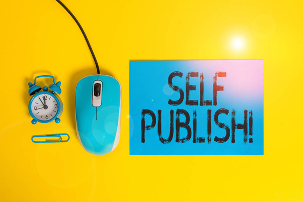 Tekst pisania słów Self Publish. Koncepcja biznesowa dla pisarza publikować kawałek z nich pracować samodzielnie na własny koszt Blank papier arkusz budzik klip drut myszy gadżet kolorowe tło. - Zdjęcie, obraz