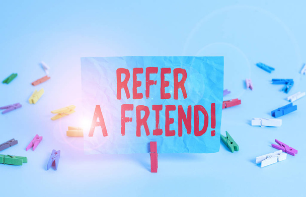 Writing note showing Refer A Friend. Business photo showcasing direct someone to another or send him something like gift Colored clothespin rectangle square shaped paper light blue background. - Photo, Image