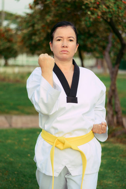 Κολομβιανή και Λατινοαμερικανίδα γυναίκα που ασκεί taekwondo άμυνα στη δεξιά θέση γροθιά επάνω - Φωτογραφία, εικόνα