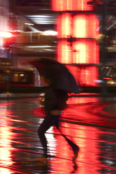 Στοκχόλμη, Σουηδία Μια γυναίκα με ομπρέλα που τρέχει στη βροχή στο Sergels Torg. - Φωτογραφία, εικόνα