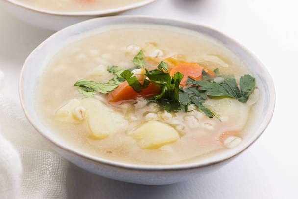 Ячменный суп, жемчужный ячмень в белой миске
 - Фото, изображение