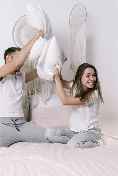 Young adult boyfriend and girlfriend spending morning in bedroom - Foto, imagen