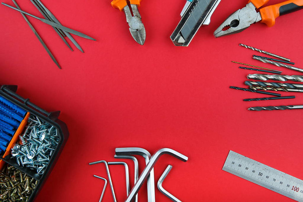 different tools on red background with copy space flat lay. - Photo, image