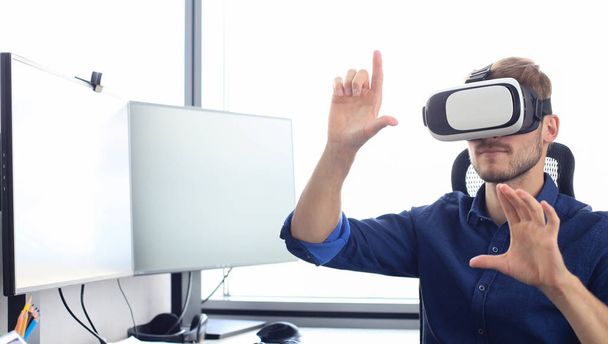 Young man wearing virtual reality glasses in modern interior design coworking studio. - Fotografie, Obrázek