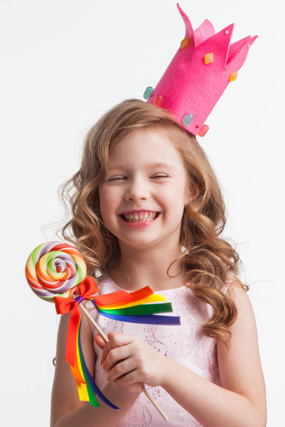 Girl in crown holding lollipop - Foto, afbeelding
