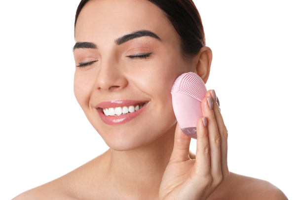 Young woman using facial cleansing brush on white background, closeup. Washing accessory - Photo, image