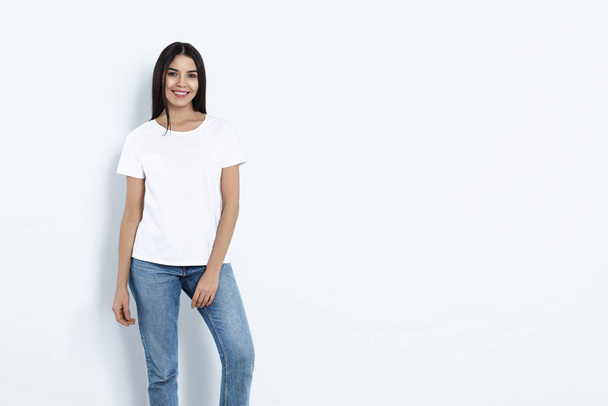 Young woman in stylish jeans on light background. Space for text - Photo, image