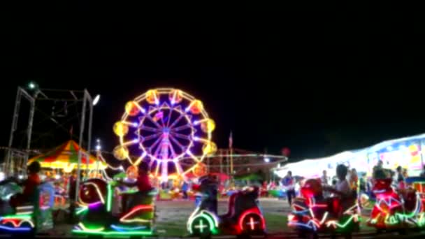 elmosódott körhinta és óriáskerék és neon fény a vonat az éjszakai piacon fair1 - Felvétel, videó
