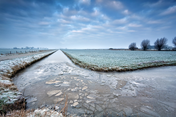 gelo partido no rio congelado em terras agrícolas neerlandesas
 - Foto, Imagem