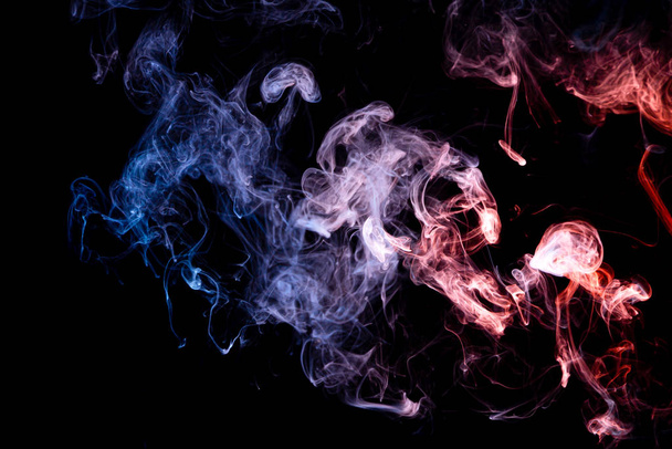 Antecedentes da fumaça do vape. Fumo de bomba azul e vermelho em fundo isolado preto
 - Foto, Imagem