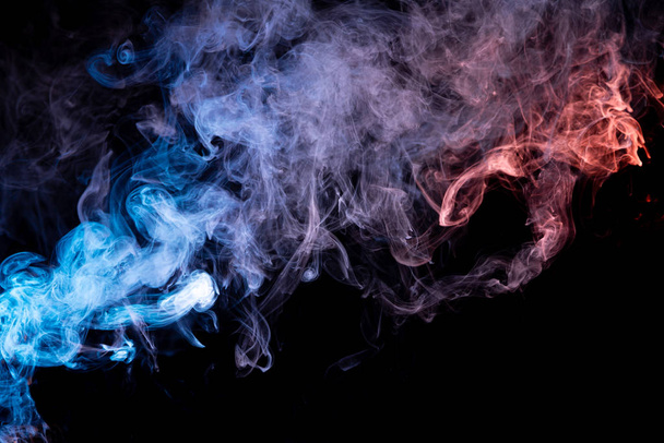 Abstract art blue and red colored smoke on black isolated background. Stop the movement of multicolored smoke on dark backgroun - Φωτογραφία, εικόνα