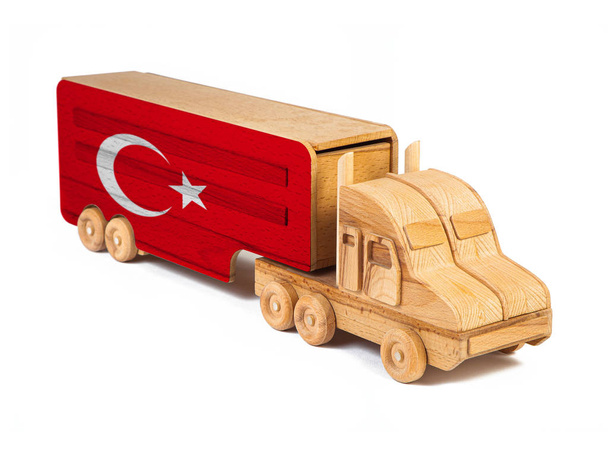Close-up van een houten speelgoedtruck met een geschilderde nationale vlag Turkije. Het concept van export-import, transport, nationale levering van goederen  - Foto, afbeelding