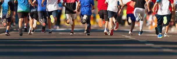 Correndo crianças, jovens atletas correm em uma corrida infantil, correndo na cidade detalhe estrada nas pernas
 - Foto, Imagem