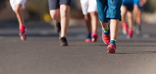 Laufkinder, junge Sportler laufen in einem Kinderlauf, laufen auf der Stadtstraße Detail auf Beinen - Foto, Bild