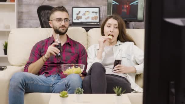 Hermosa pareja joven sentada en el sofá
 - Imágenes, Vídeo