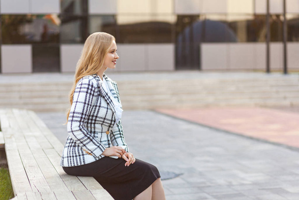 Side view of beautiful elegant successful businesswoman sitting  - Фото, зображення