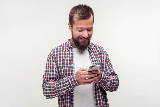 Mobile communication. Portrait of cheerful bearded man using cel - 写真・画像